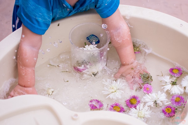 Toddler playing with water of Flower Sensory Soup. 