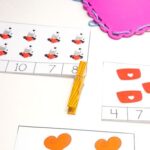 A photo of three Valentine's Day Counting Cards and Puzzles on a table