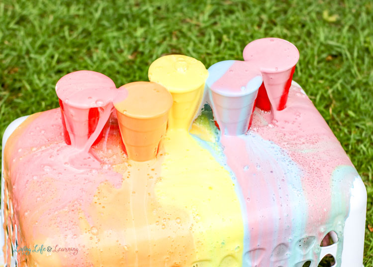 Watch the colorful bubbles ooze and spurt out of this rainbow pop and Mentos experiment. 