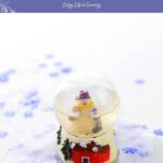 The image shows a snow globe on top of a snowy winter-themed slime