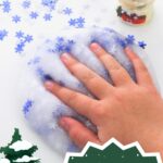 A hand is placed on top of the slime that has snowflake confetti.The snow globe is to the right behind the slime with more snowflake confetti to its left. The text is placed at the bottom of the image saying "winter slime recipe"