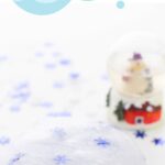 The snow globe is to the right behind the slime with snowflake confetti. The text is placed on top of the image saying "winter slime recipe"