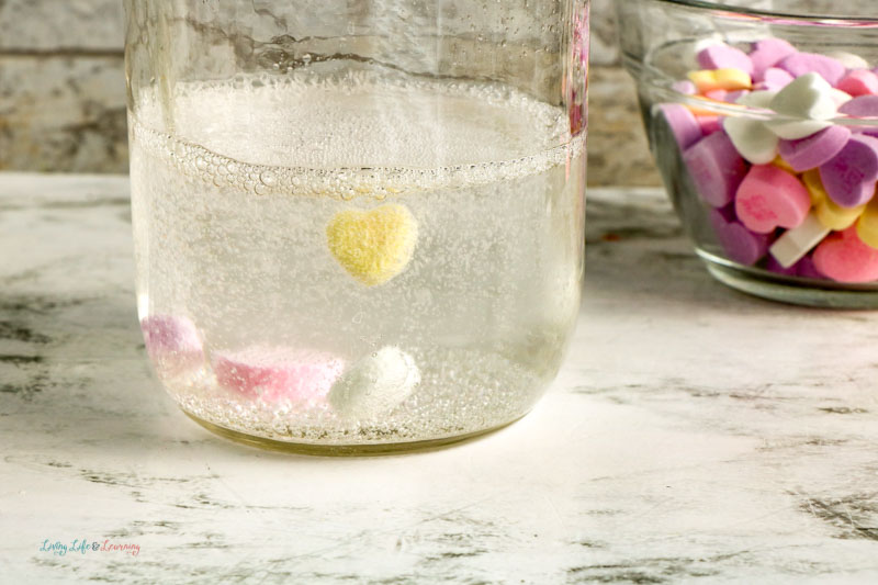 A jar showing a heart rising to the top during the dancing hearts experiment. 