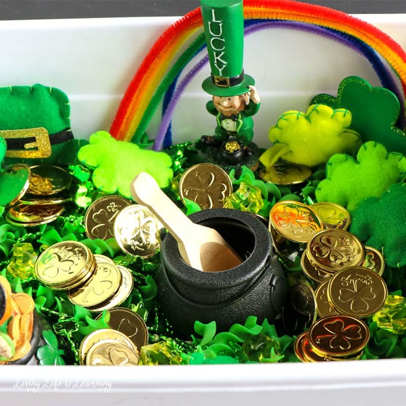 St Patrick's day sensory bin with gold coins, green past and toys
