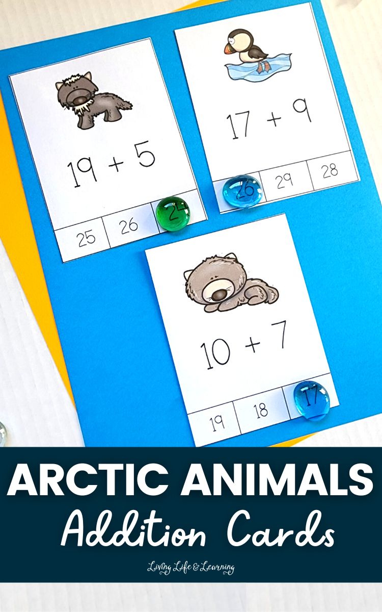 There are three arctic animal addition cards on top of the blue-colored paper which also has a yellow-colored paper beneath it.