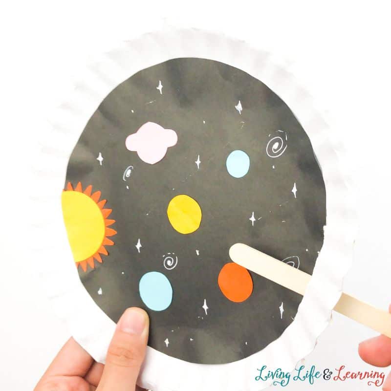 Putting a popsicle stick at the slit of the paper plate Spaceship Craft