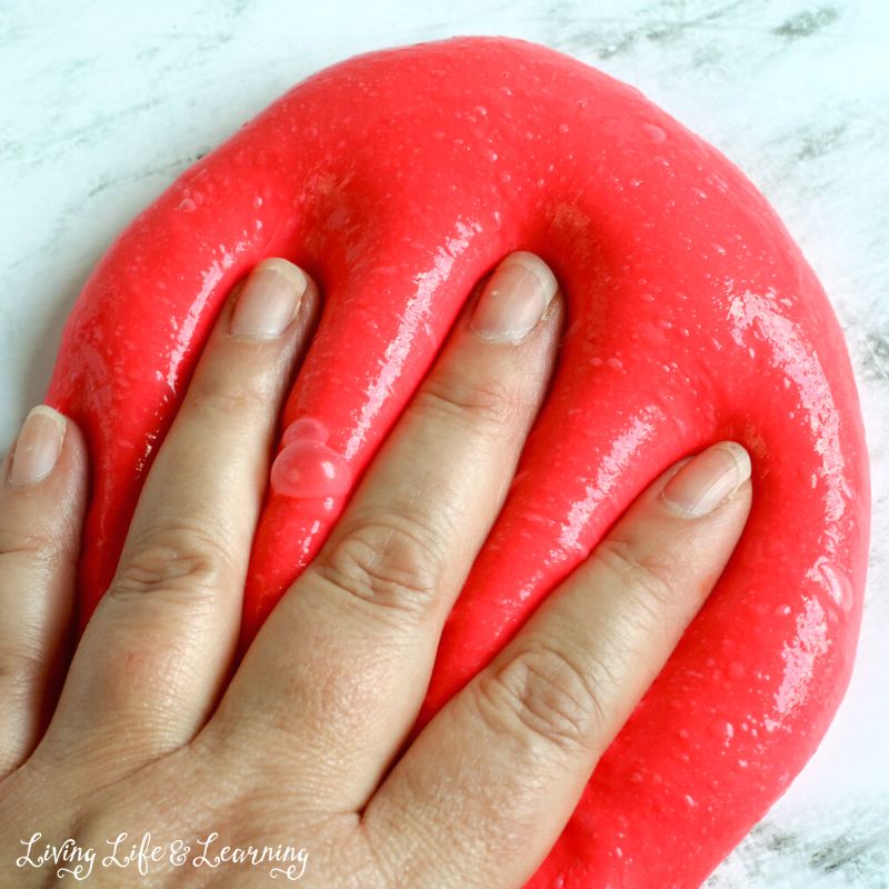 A hand kneading the Red Apple-Scented Slime Recipe.
