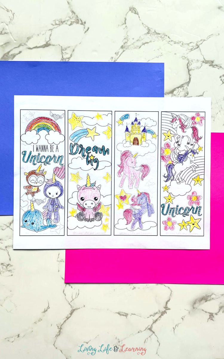 Four uncut Printable Unicorn Bookmarks on a table