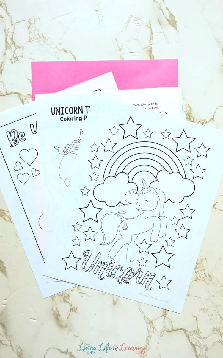 Three Unicorn Coloring Pages on a table